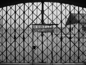 Entrance gate of Dachau Concentration Camp with the inscription 'Arbeit Macht Frei,' symbolizing the atrocities of the Holocaust.